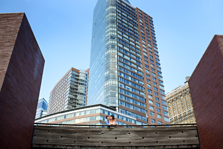 A couple in love hug on a bridge in Battery Park for their Engagement Session with Russ Hickman Photography.